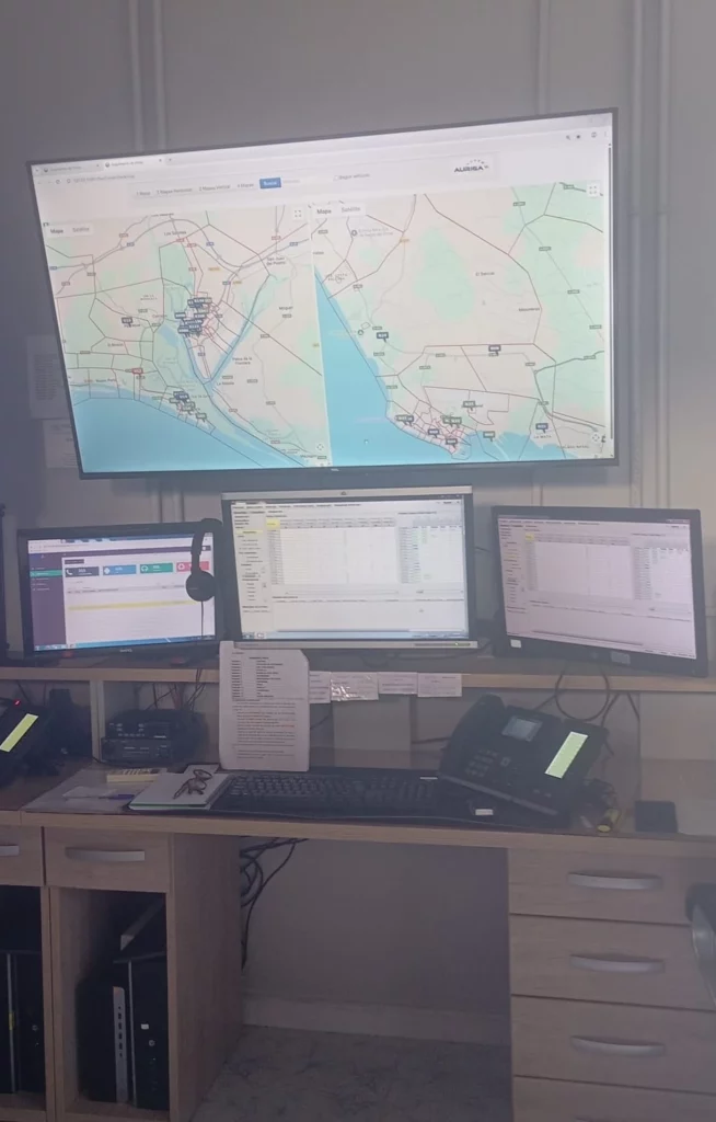 Estación de trabajo con cuatro pantallas mostrando mapas y datos de monitoreo de tráfico.